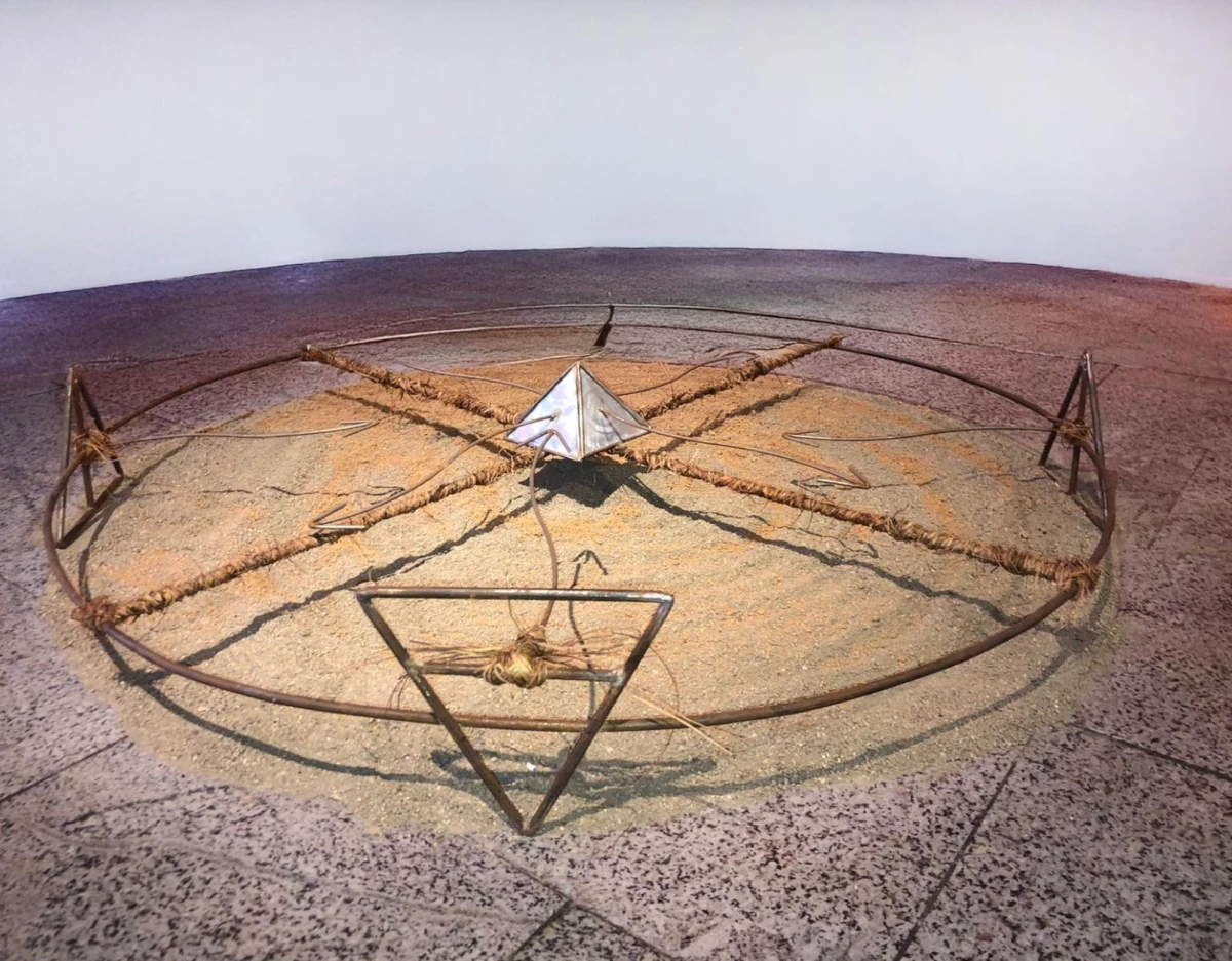 Gira X, Installation, 2024. Acier, lianes, terre noire et rouge. Sculpture, 120 x 120 cm. Pliage, soudure et ligature.